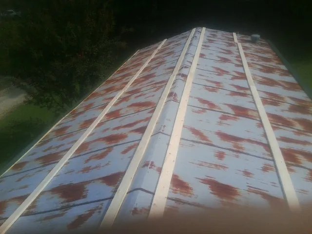 Rusted metal roof panels with new wood purlins before replacement — Storm Damage Roof Repair in Port Penn by Roofing Brothers
