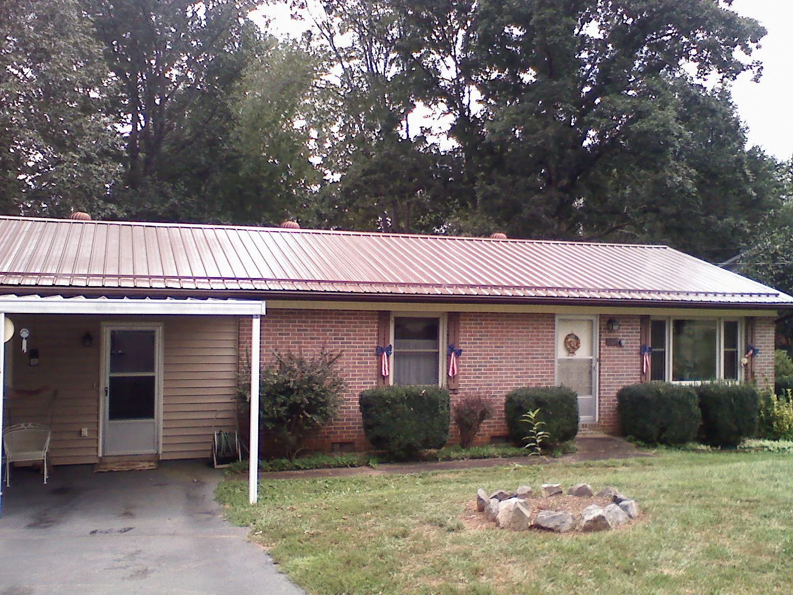 Bronze metal roof and carport on a brick ranch home — Roof Repair work by our crew in Port Penn