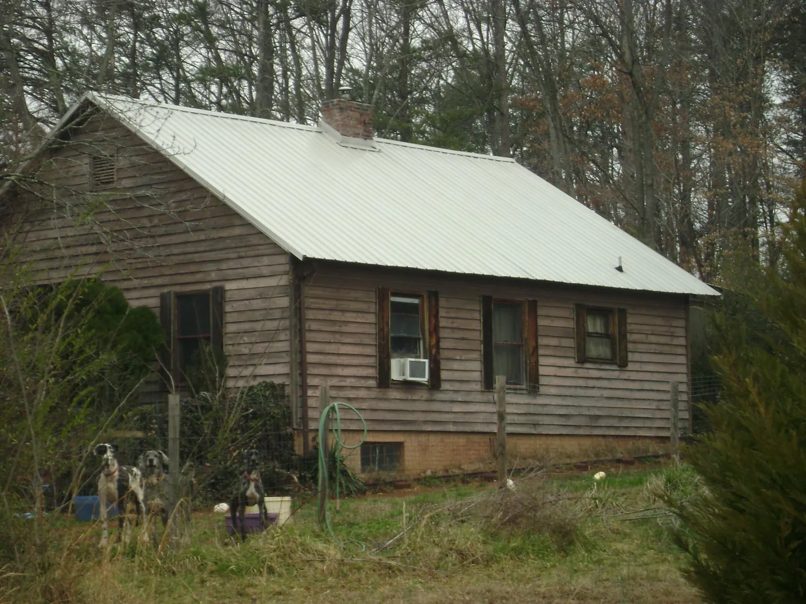 White metal roof on an old wood sided farmhouse, from a Metal Roof Installation job in Port Penn